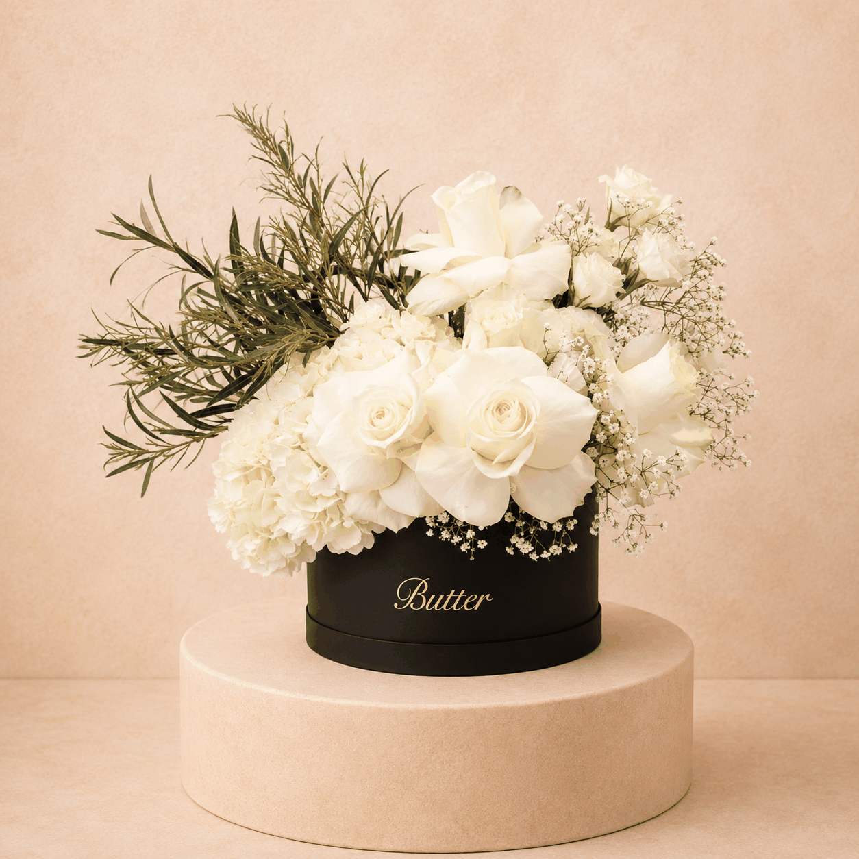 elegant flower arrangement in hat box featuring white roses, hydrangea, and baby&