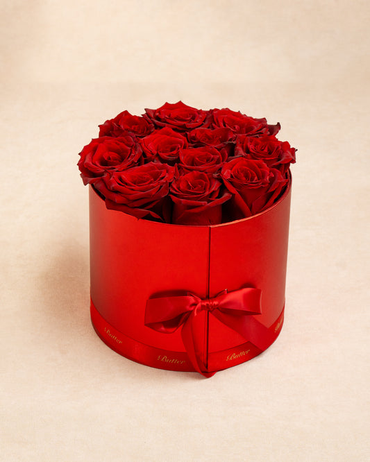 Luxury Gift Box with 12–15 deep red roses arranged atop a matte crimson box. luxurious, romantic, and perfect for expressing love.