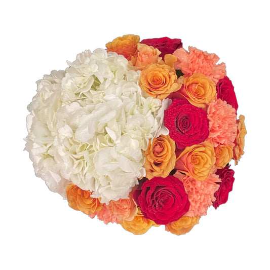 A medium-sized round matte white box featuring a vibrant mix of hydrangeas, roses, baby roses, and carnations in warm orange, red, and yellow tones.